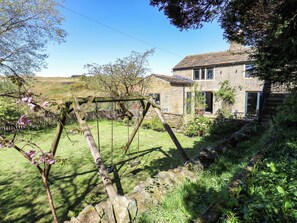 A stone house with a swing set in a grassy yard. - Rocks Cottage (Halifax)