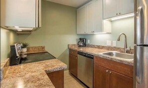 A compact kitchen with a built-in oven, a dishwasher, a sink, and a refrigerator. - Downtown Lincoln. Park once. Walk every where. Minutes to Loon. Pet friendly, (Lincoln)