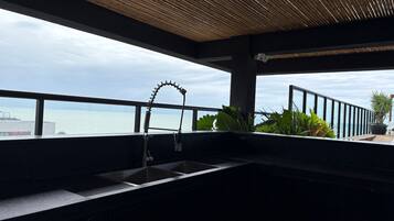 Een moderne buitenkeuken met uitzicht op zee.