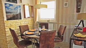 Et spiseområde med et rundt bord, fire stole og en lampe.