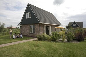 Une maison à deux étages, avec un toit sombre et une façade en briques.