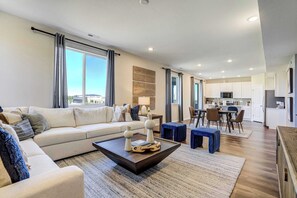 Ein modernes Wohnzimmer mit Sofa, Couchtisch und Essbereich.