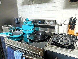 A kitchen with a stainless steel stove, a blue kettle, and a muffin tray. - Just Us River Retreat (Weeki Wachee)