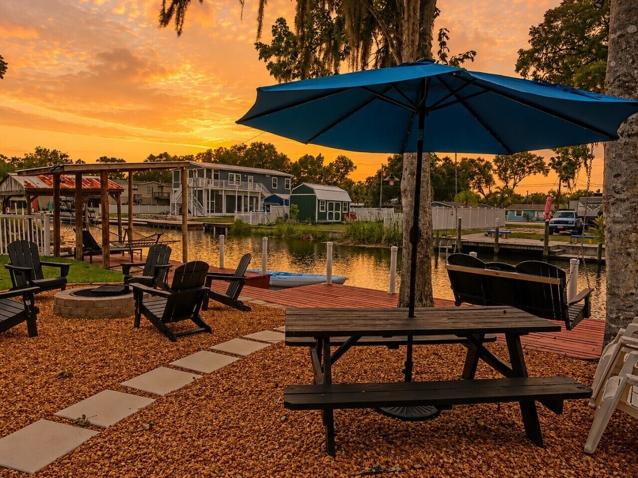 A waterfront patio with outdoor seating, a dock, and a boat.