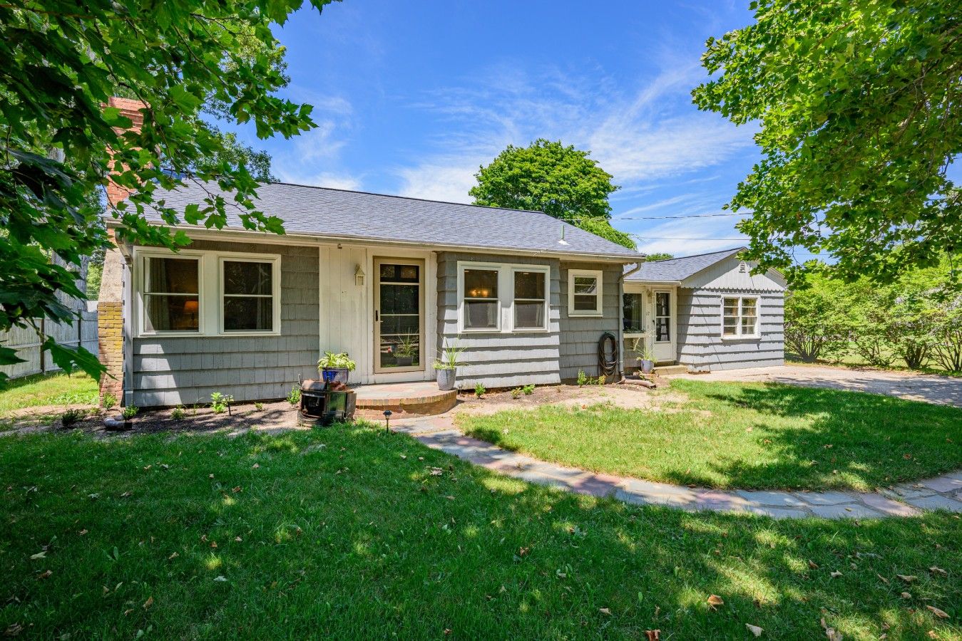 A single-story house with a front porch, a small attached garage, and a well-maintained lawn.