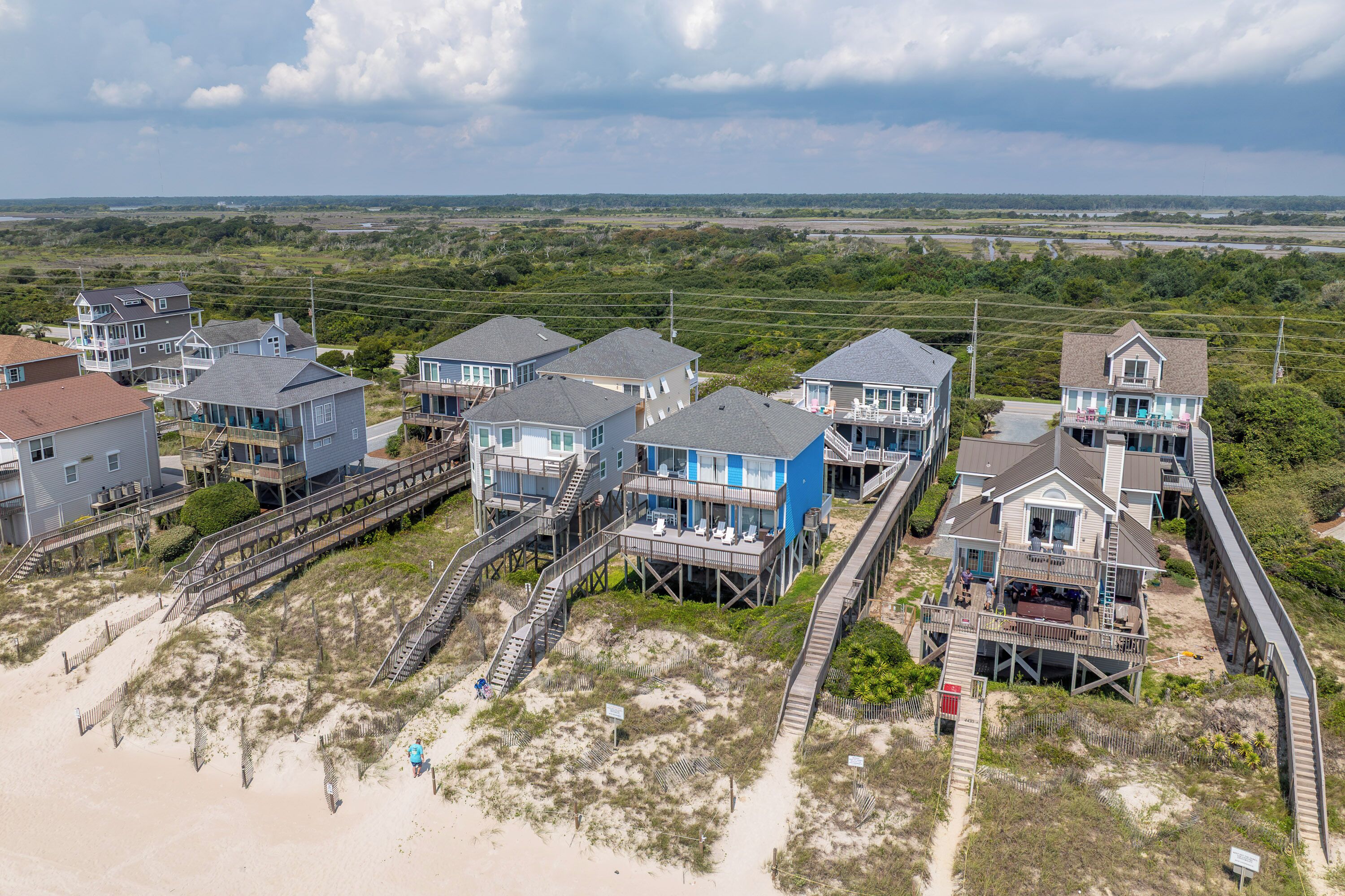 A coastal residential area with multiple houses connected by wooden walkways.