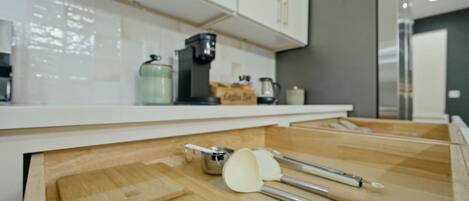 Una cocina con tablas de madera, un cuchillo y una olla sobre el mostrador.