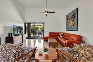 A modern living room with a sectional sofa, a coffee table, and patterned chairs. - Rose Garden Escape - Stylish 2 Bedroom Condo (Palm Springs)