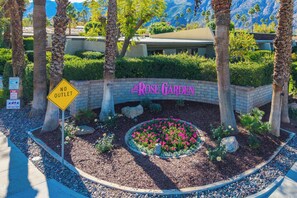 A landscaped area with a sign for 'Rose Garden' and a 'No Outlet' sign. - Rose Garden Escape - Stylish 2 Bedroom Condo (Palm Springs)