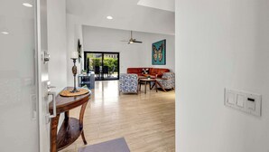 Ein modernes Wohnzimmer mit einer Couch, Sesseln, einem Couchtisch und einem Essbereich mit Tisch und Stühlen.