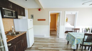 A kitchen with dark wooden cabinets, a white refrigerator, and a microwave.