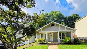 A single-story house with a front porch, a driveway, and a well-maintained lawn.
