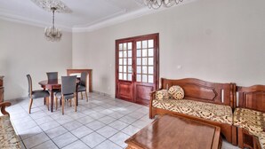 Ein geräumiges Wohnzimmer mit Essbereich, einem Holzdavonia, einem Kronleuchter und einem großen Fenster.