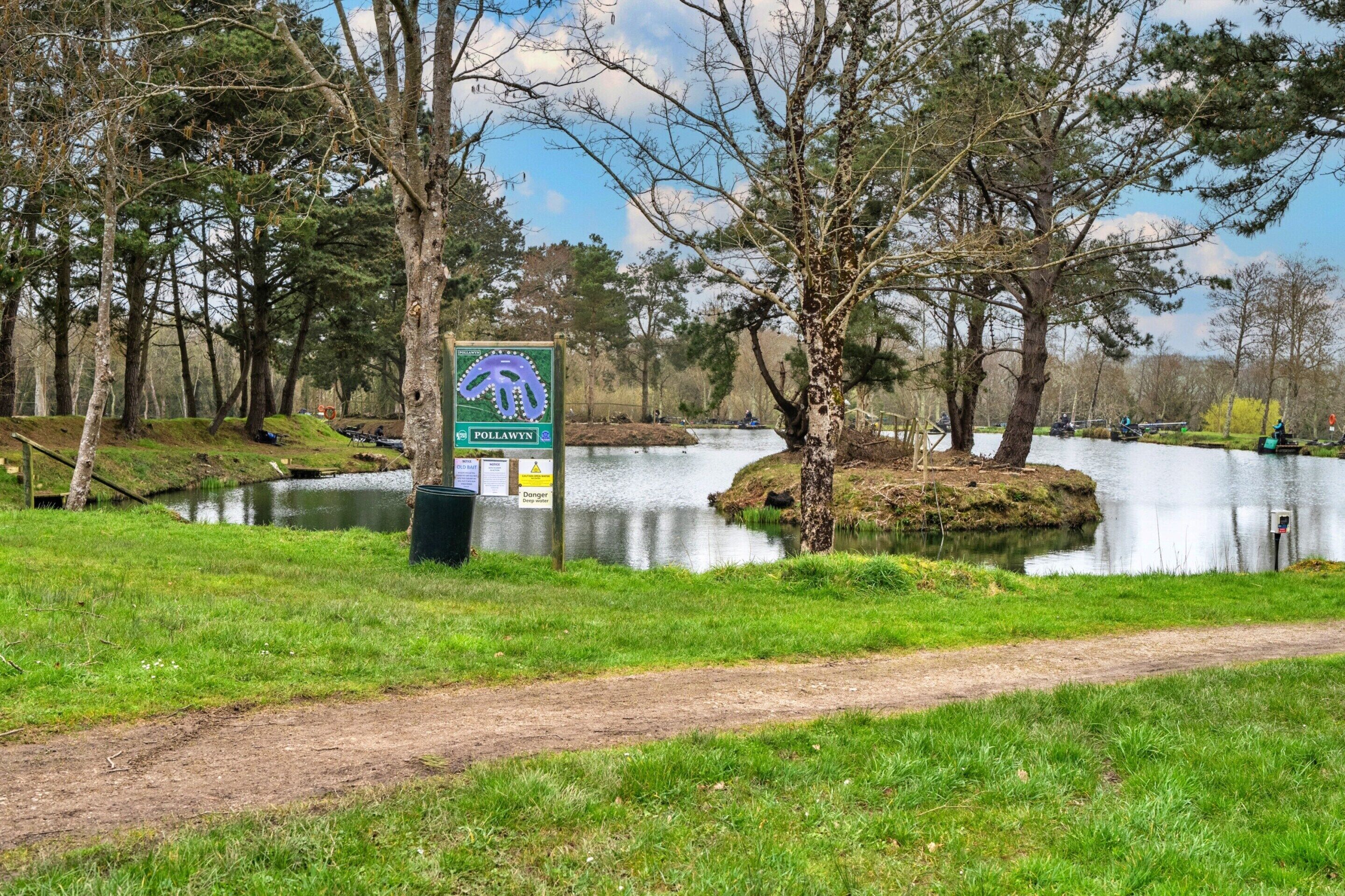 A signpost with a directional arrow, a path, and a body of water.