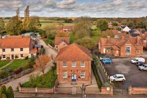 A village with traditional brick houses, a central village hall, and a gravel driveway. - Charming Chapel House Norfolk (Dereham)