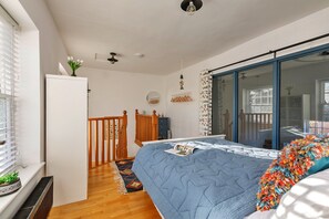 A bedroom with a bed, a dresser, a mirror, a window with blinds, and a ceiling fan. - Charming Chapel House Norfolk (Dereham)