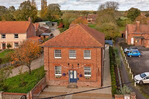 A two-story brick house with a tiled roof, a front door, and a small porch. - Charming Chapel House Norfolk (Dereham)