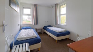 A small, clean room with two single beds, a desk, and a chair. - Elegant Waterfront Bungalow With Jetty (Makkum)