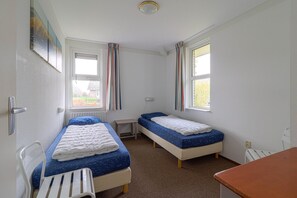 A small, clean room with two single beds, a desk, and a chair. - Elegant Waterfront Bungalow With Jetty (Makkum)