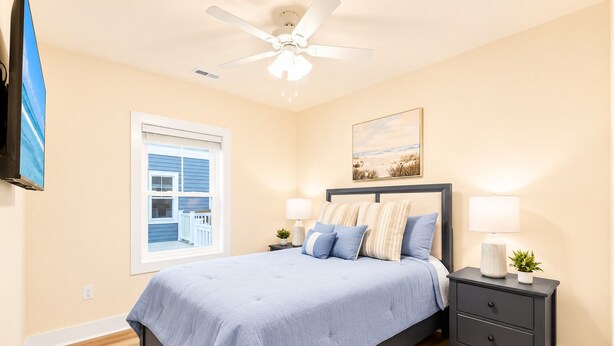 A bedroom with a bed, bedside tables, a ceiling fan, a window with blinds, and a painting on the wall. - Spacious 4-bedroom townhome in fabulous Ocean City with AC (Ocean City)