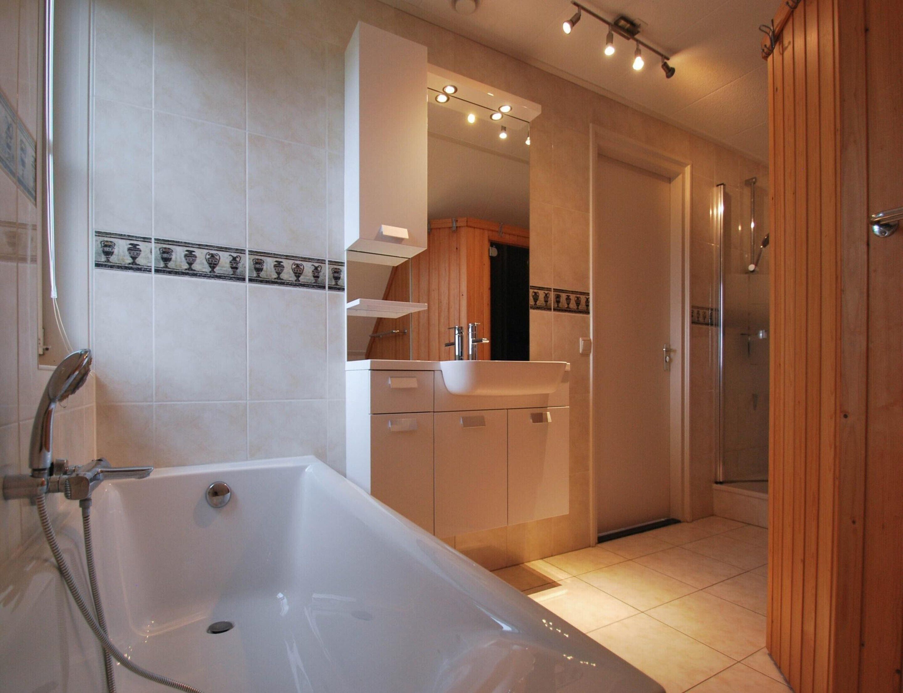 A modern bathroom with a bathtub, a sink, and a shower area.