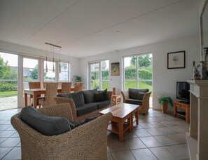 A spacious living area with a sofa, chairs, a table, and a television. - Attractive Dune Villa With Sauna (Makkum)