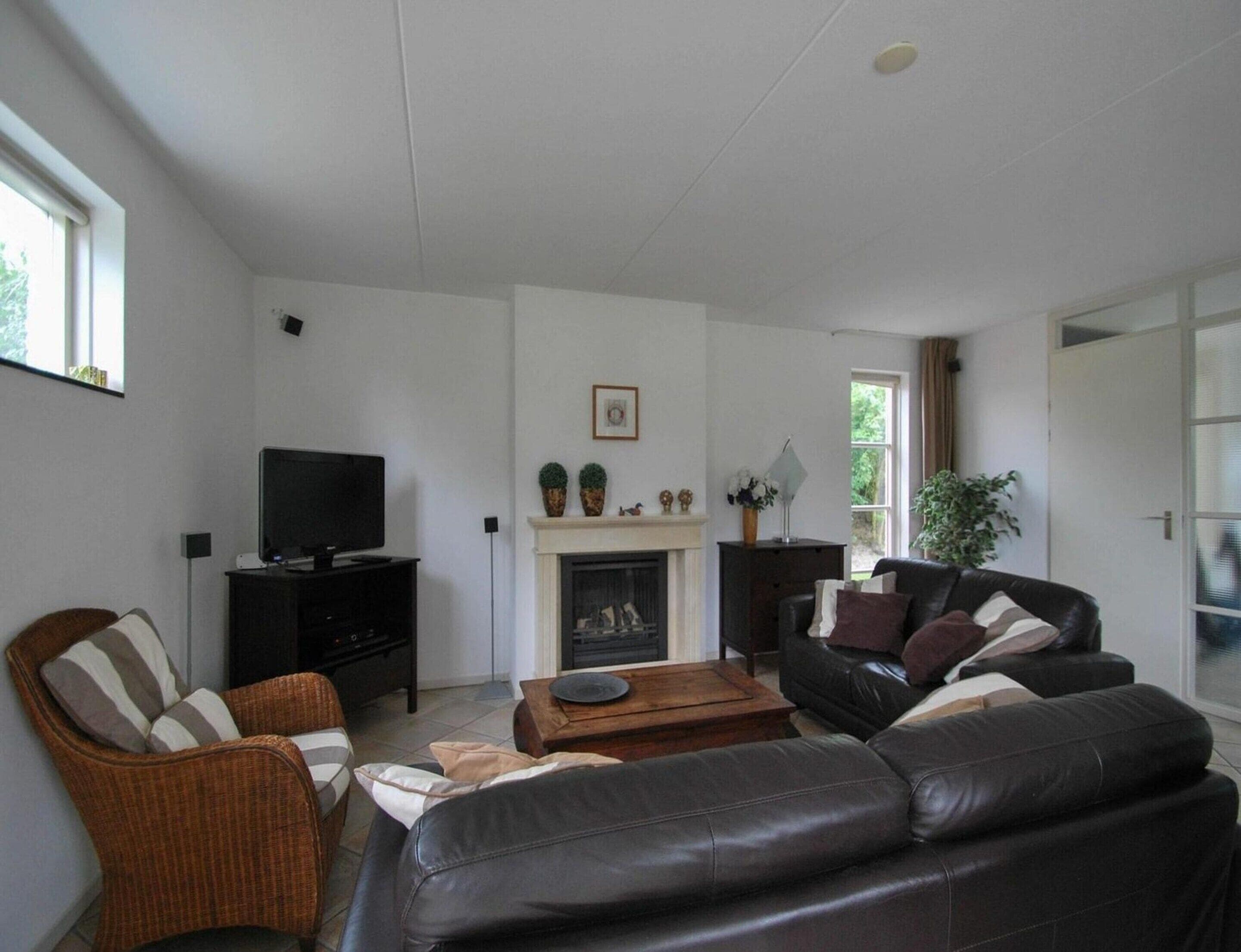 A living room with a fireplace, a television, and a sofa.