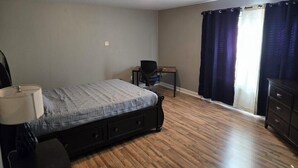 A bedroom with a bed, a desk, a chair, and a dresser. - CORP HOUSING:::
Spacious 5-bedroom house in amazing Winston-Salem with AC (Winston-Salem)