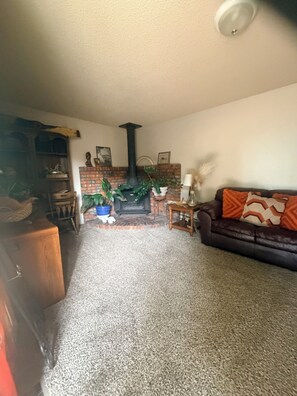 A living room with a fireplace, a sofa, a coffee table, and a bookshelf.