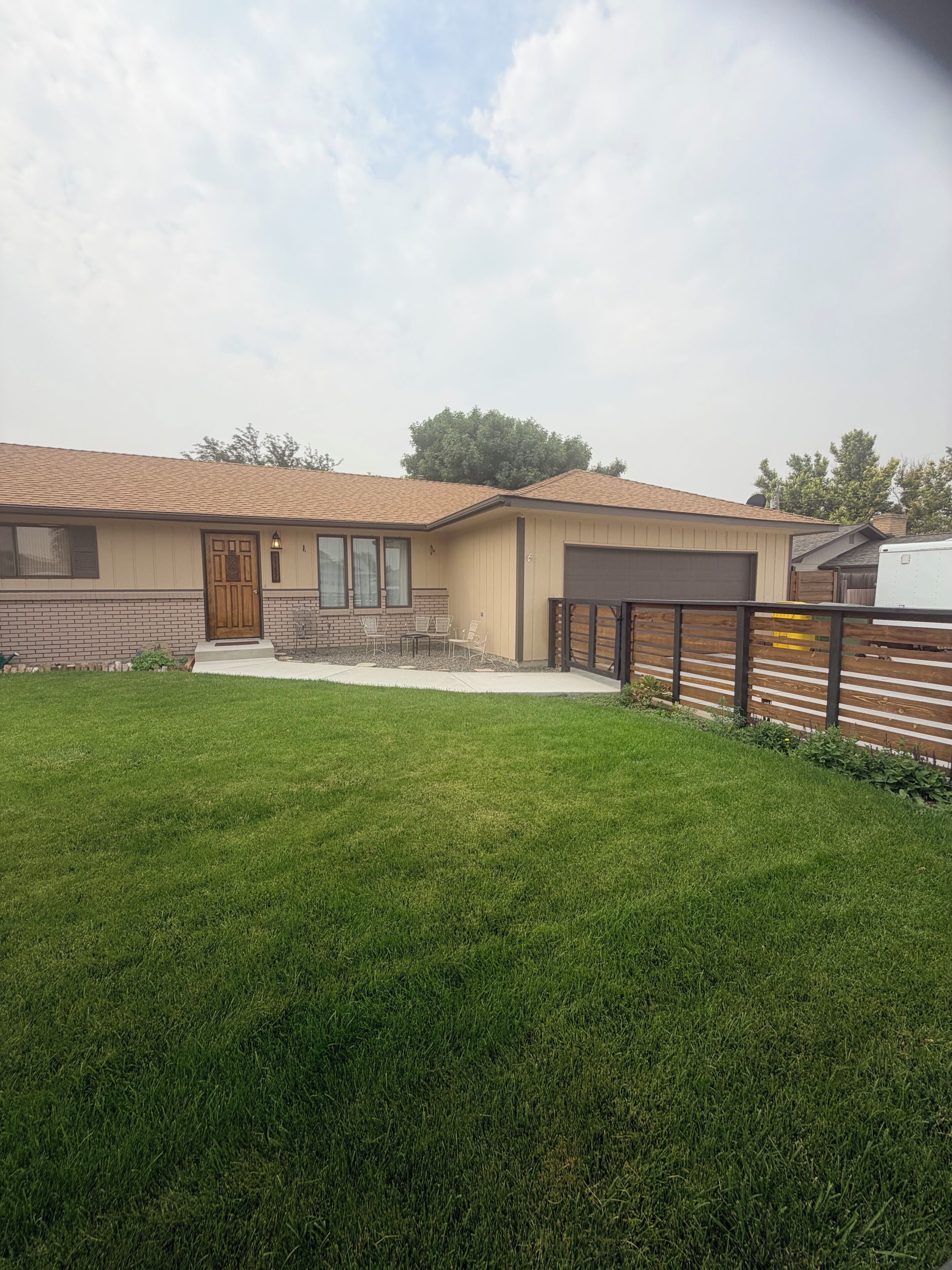 A single-story house with a front porch, a garage, and a well-maintained lawn.