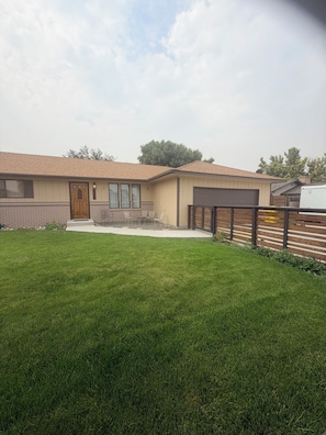 A single-story house with a front porch, a garage, and a well-maintained lawn.