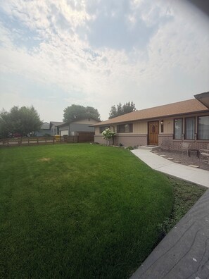 Un quartier résidentiel avec des maisons, une pelouse bien entretenue et une clôture en bois.