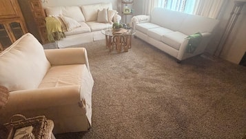 A living room with two sofas, a coffee table, and a lamp.