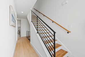 Eine Treppe mit Holzbodenstufen und schwarzen Metallgeländern, die zu einer oberen Etage führt.