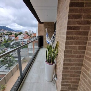 A balcony with a potted plant, a hammock, and a view of the cityscape. - ✨ Cozy and comfortable apartment with a pool and spa in the Financial District (Bogotá)