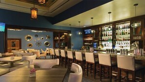 A bar area with multiple seating options, a variety of bottles on shelves, and decorative wall elements. - Free Valet Parking MGM Studio 1911 (Las Vegas)