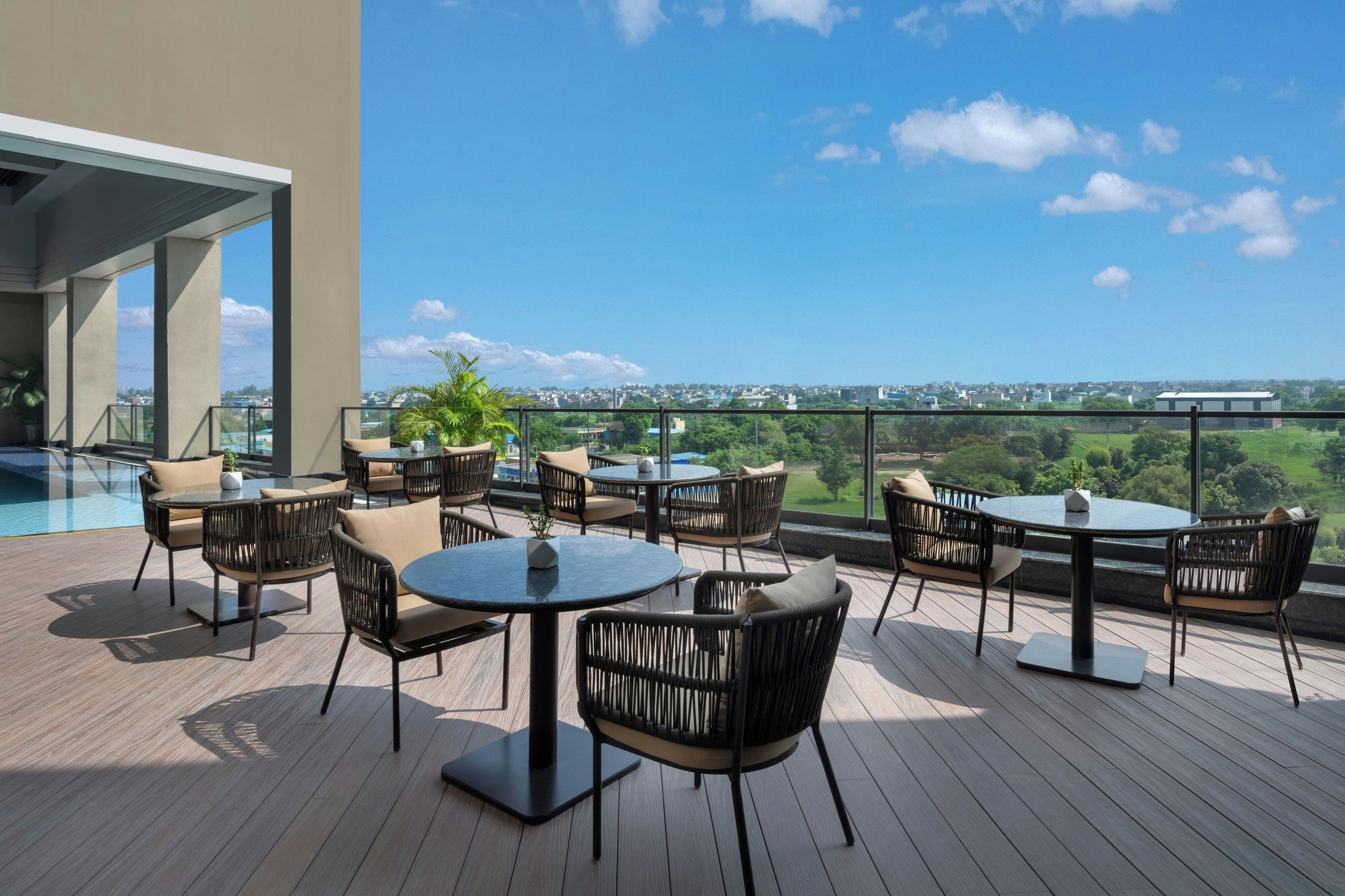 Une terrasse sur le toit avec des sièges extérieurs et vue sur la piscine.