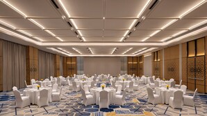 A conference room with round tables, white chairs, and a patterned carpet. - Courtyard by Marriott Ghaziabad India (Ghaziabad)