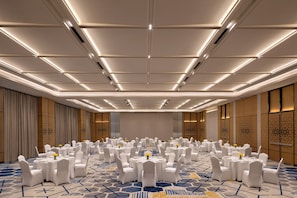 A conference room with round tables, white chairs, and a patterned carpet. - Courtyard by Marriott Ghaziabad India (Ghaziabad)