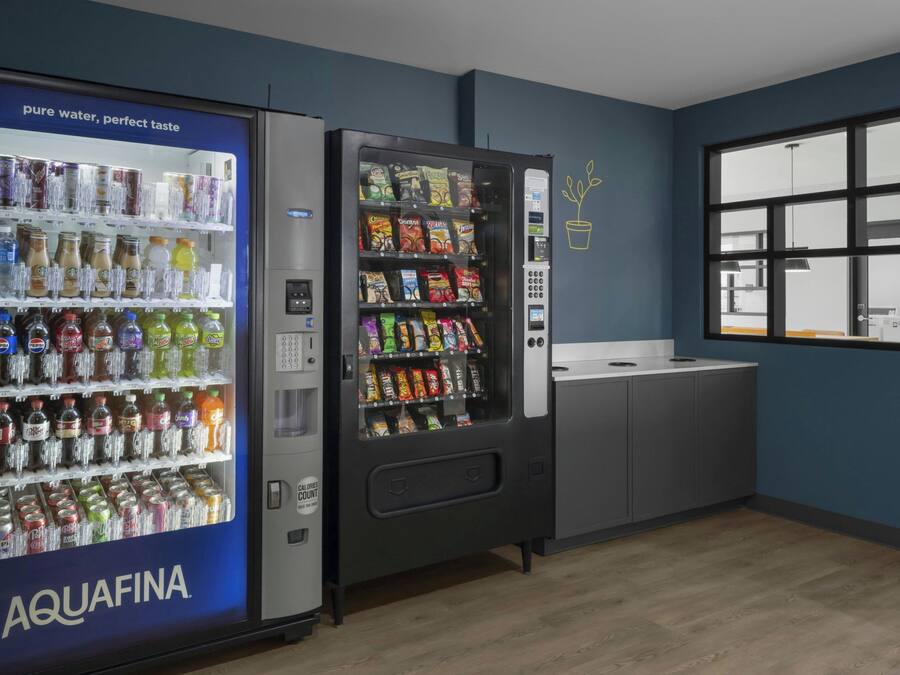 Ein Automatenbereich mit einem Wassenspender mit dem Aufdruck AQUAFINA und einem Snackautomaten.