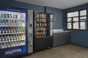 A vending machine area with a water dispenser labeled AQUAFINA and a snack vending machine.