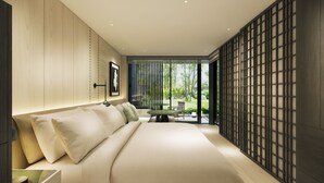 Un dormitorio moderno con una cama grande, una mesa de comedor y vista a un jardín.