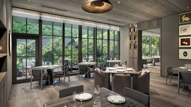 Un interior de restaurante moderno con ventanas amplias, suelo de madera y diferentes opciones de asientos.