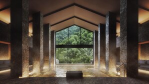 Un área de spa con un ventanal grande, pilares de piedra y suelo con calefacción.