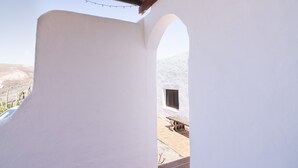 Una stanza dalle pareti bianche con una finestra vista su un paesaggio desertico.