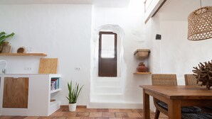 Un ambiente compatto con angolo cottura, zona pranzo e un piccolo ingresso.