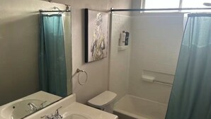 A bathroom with a sink, toilet, and bathtub.