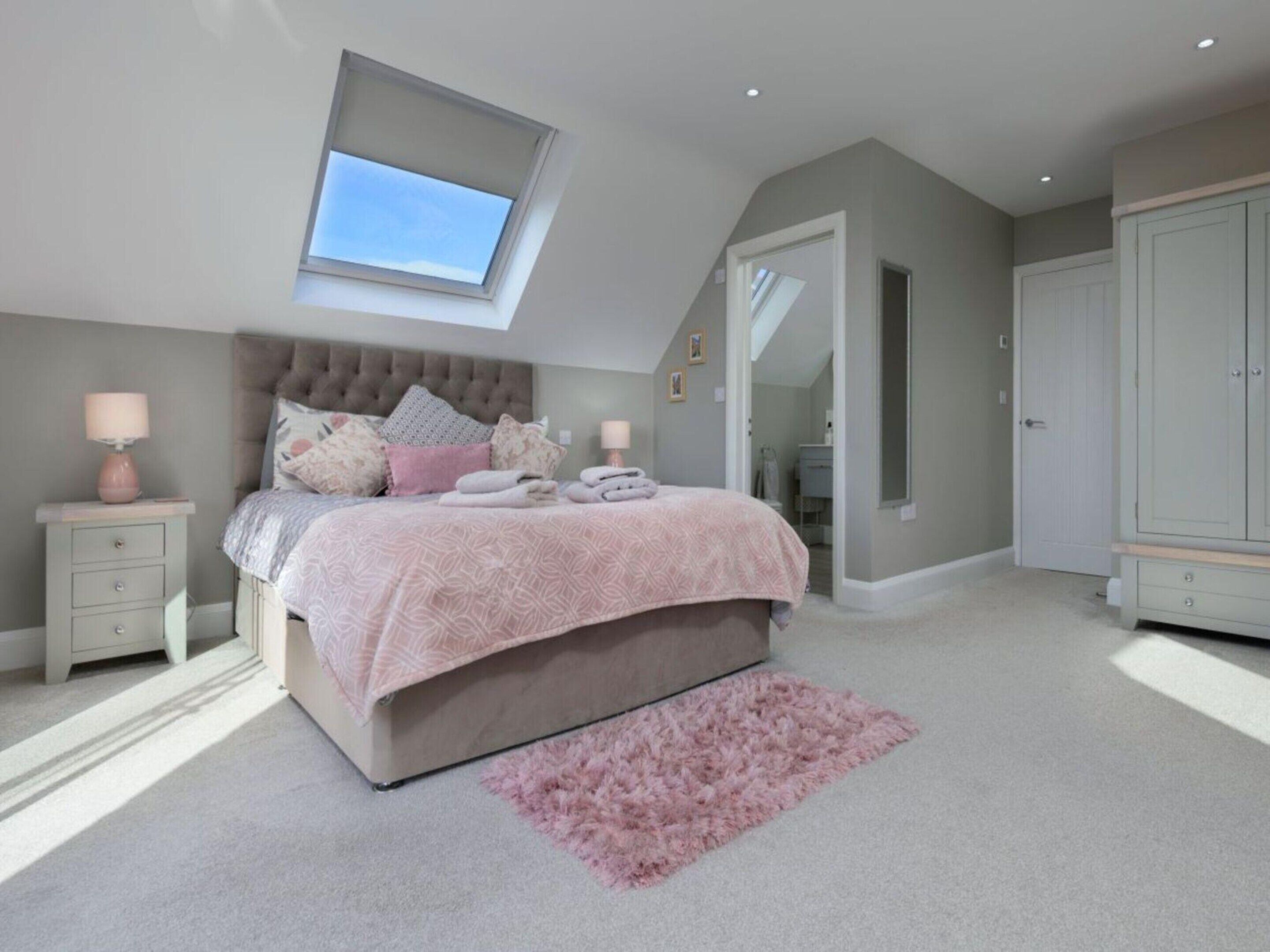 A bedroom with a bed, a nightstand, a mirror, and a wardrobe.