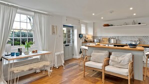 Una cocina acogedora con comedor, suelo de madera y vistas al exterior.
