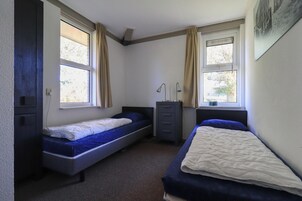 2 habitaciones, tabla de planchar con plancha y muebles diferentes